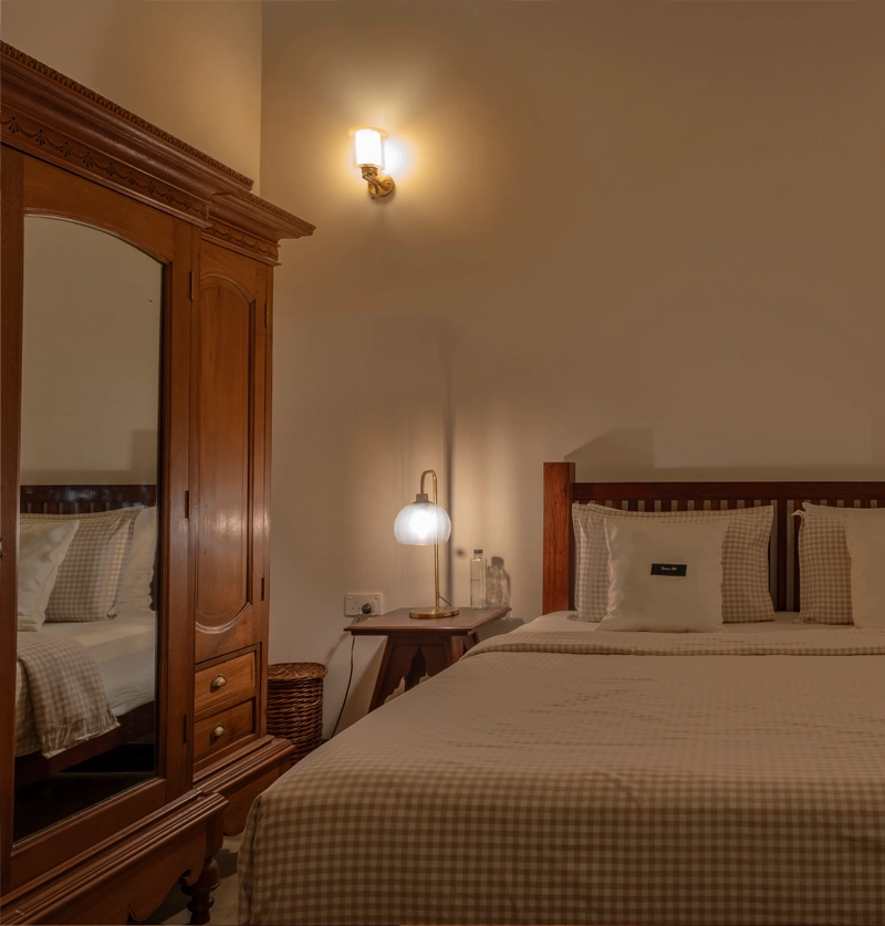 Cozy bedroom with wooden wardrobe, soft lighting, and neatly arranged double bed at Sevena Villa Weligama